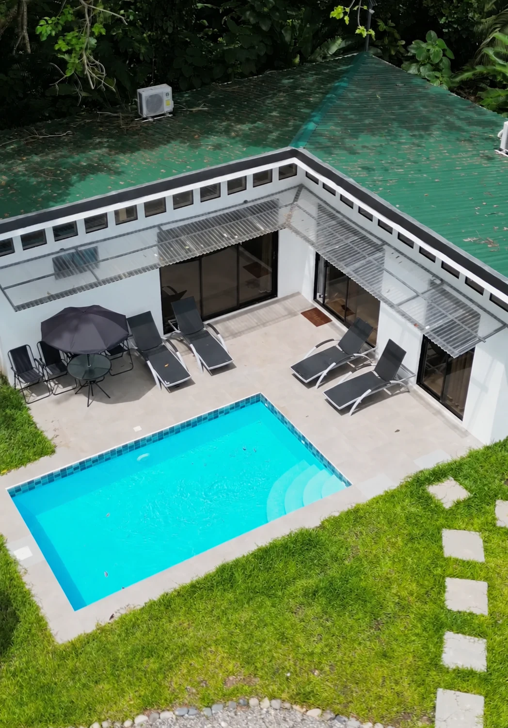Aerial view of Villa Isora and its private turquoise pool surrounded by tropical greenery