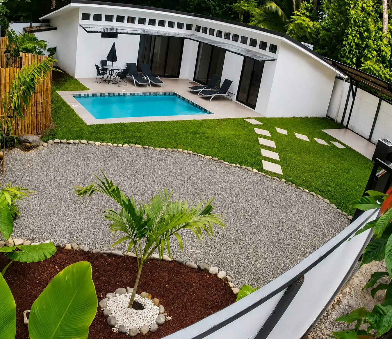 Wide view of Villa Isora, its pool and tropical garden
